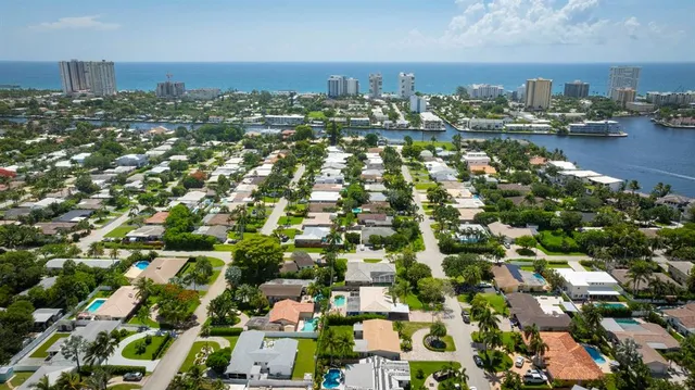 an aerial view of ocean and residential houses with outdoor space