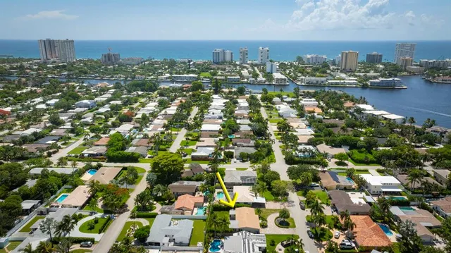 an aerial view of ocean and residential houses with outdoor space