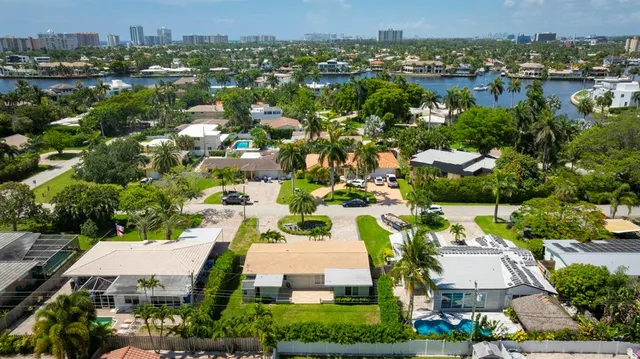 a view of a house with a yard and palm trees