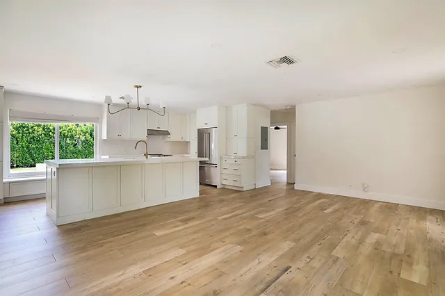 a view of kitchen with wooden floor and electronic appliances