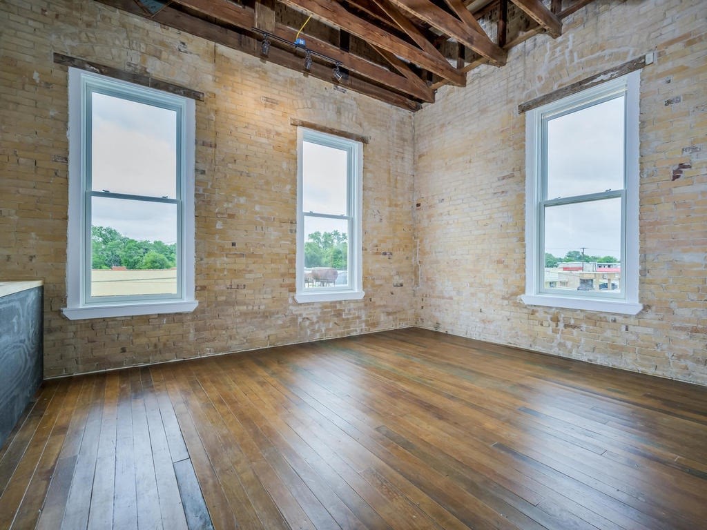 110 South Main Street, Unit 205 Elgin, TX 78621 - Photo 3 of 20 an empty room with wooden floor and windows