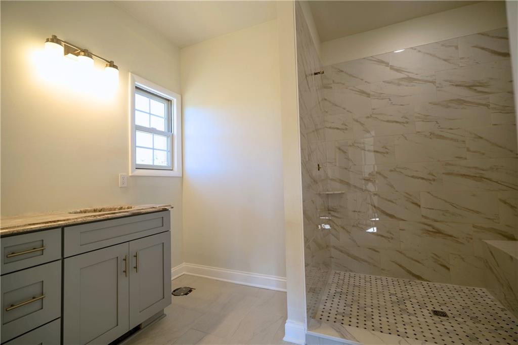 306 Hunters Crossing Canonsburg, PA 15317 - Photo 19 of 28 a bathroom with a granite countertop sink a mirror and shower