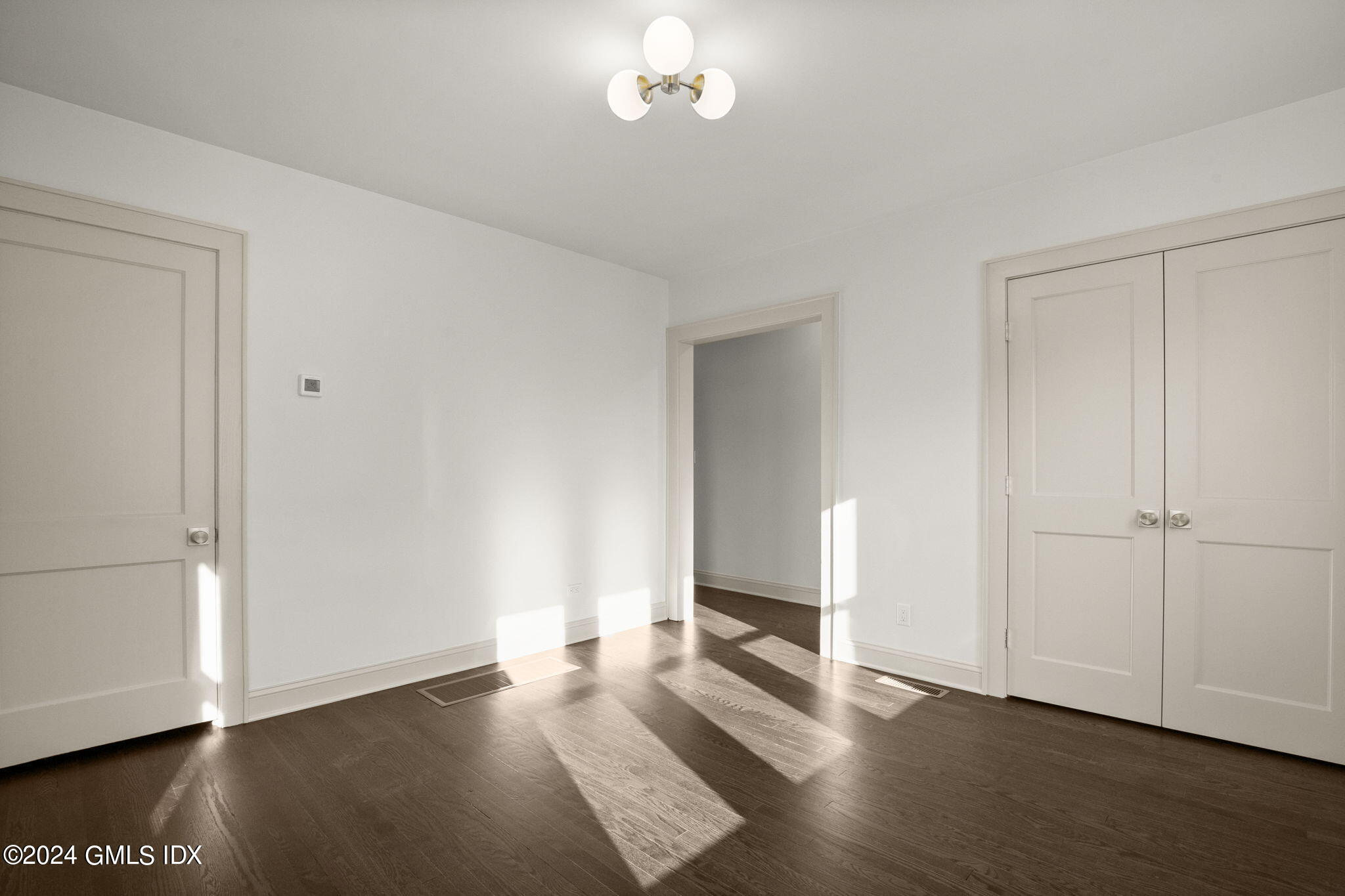 109 Byram Road, Unit B Greenwich, CT 06830 - Photo 12 of 25 an empty room with wooden floor cabinet and windows