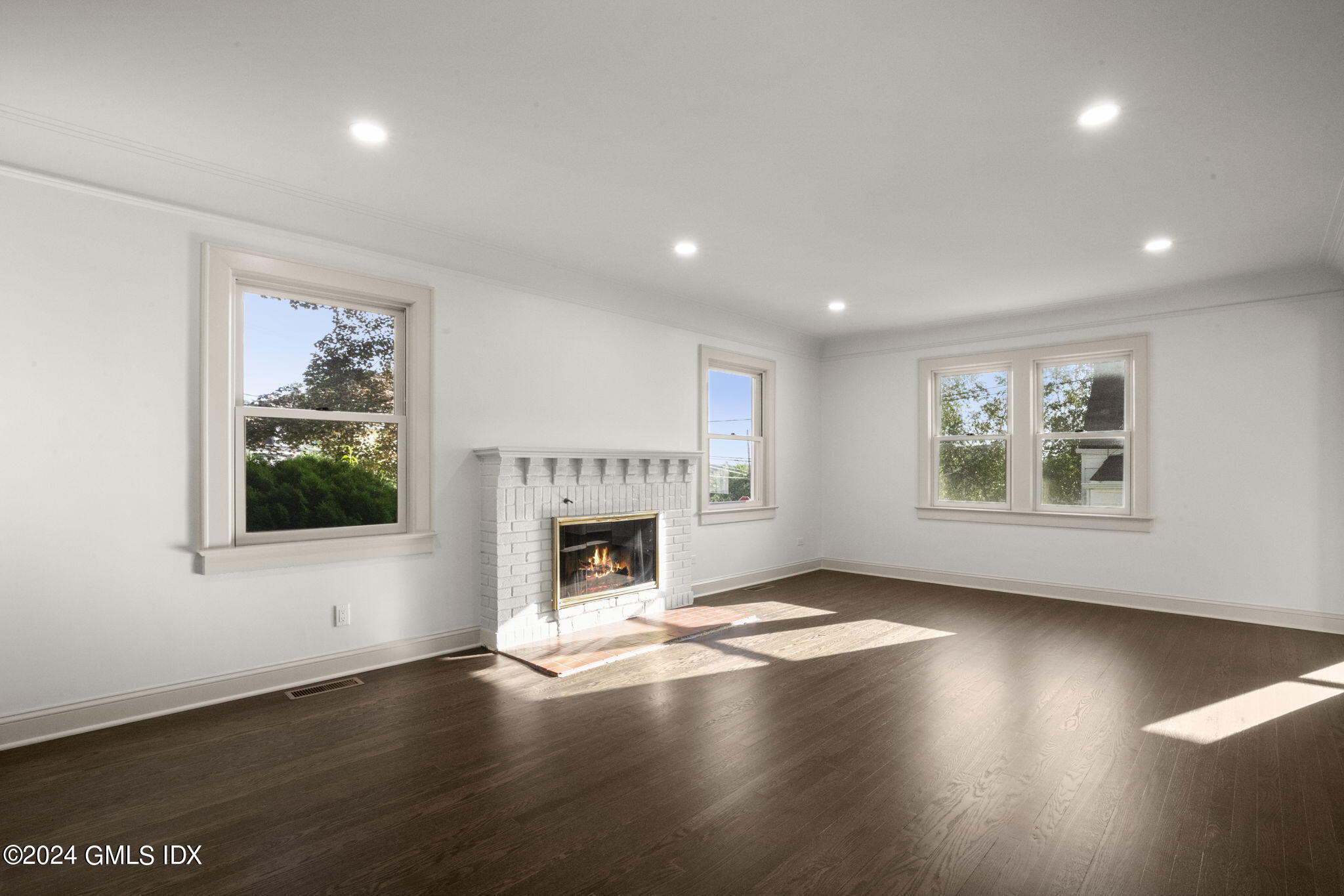 109 Byram Road, Unit B Greenwich, CT 06830 - Photo 4 of 25 a view of an empty room with a window and wooden floor