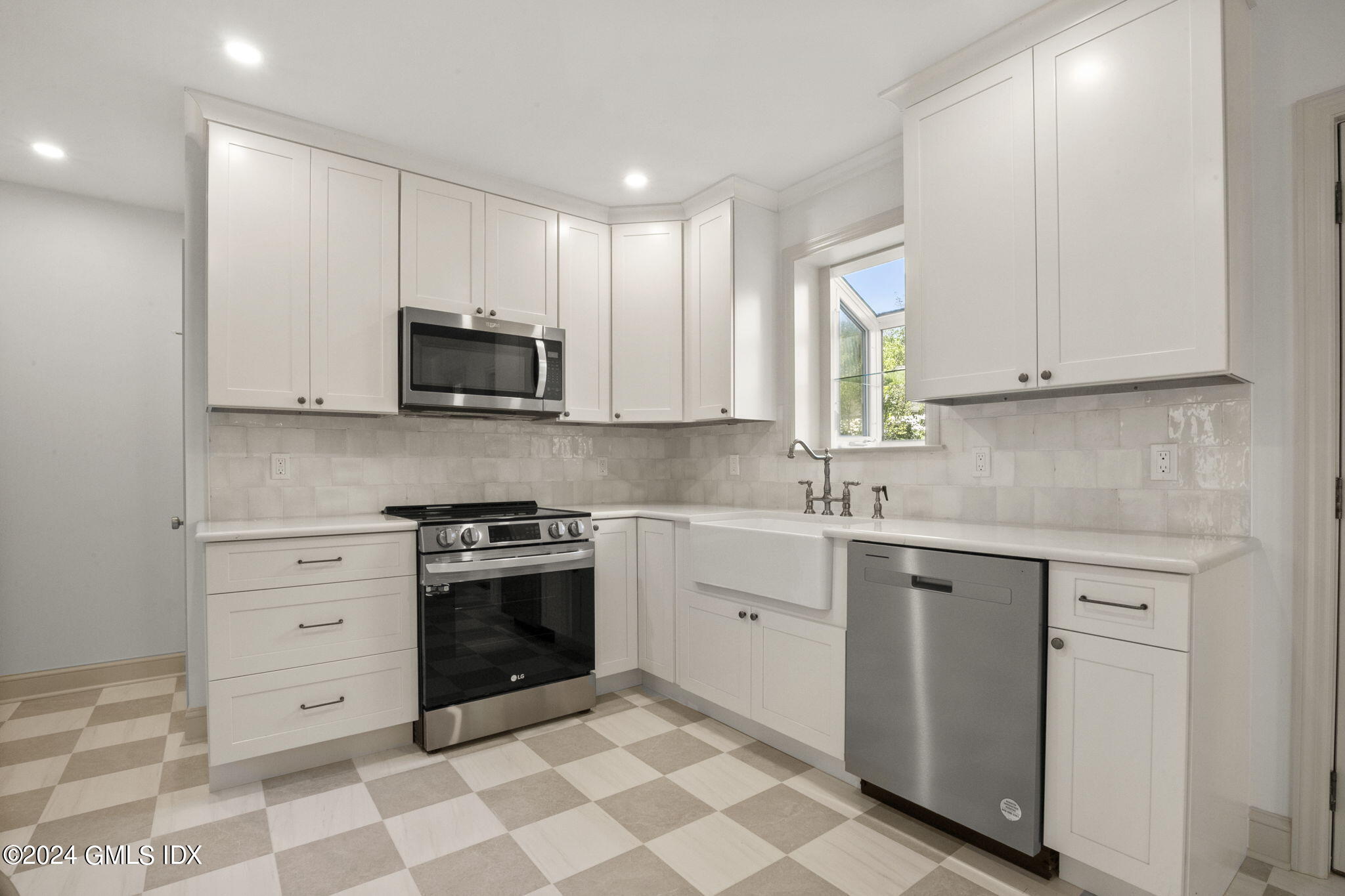 109 Byram Road, Unit B Greenwich, CT 06830 - Photo 7 of 25 a kitchen with stainless steel appliances granite countertop a stove a sink and a microwave