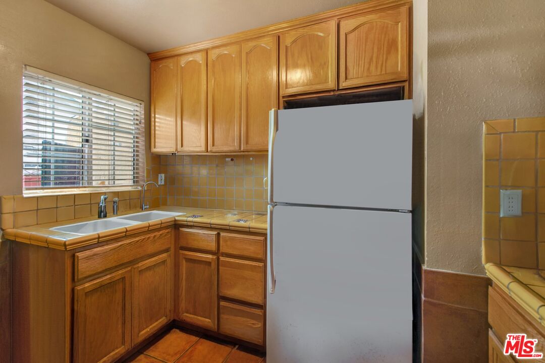 4713 Clinton Street Los Angeles, CA 90004 - Photo 6 of 25 a kitchen with a sink and a refrigerator