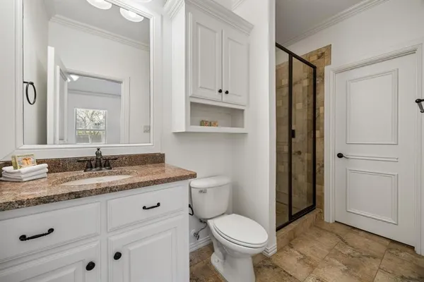 a bathroom with a granite countertop sink toilet and shower