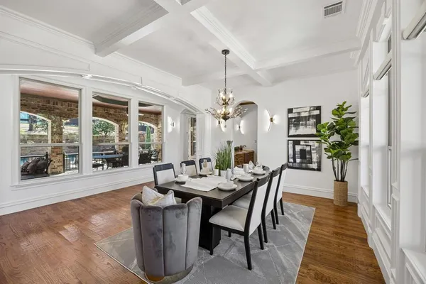 a dining room with furniture a chandelier and wooden floor