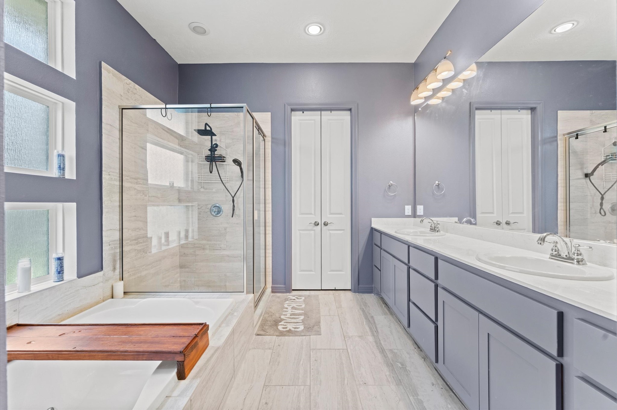 3510 Whitman Drive Rosharon, TX 77583 - Photo 10 of 25 This modern bathroom features a spacious glass-enclosed shower, a separate bathtub, dual sinks with ample counter space, and sleek cabinetry. The room is well-lit with recessed lighting and has a stylish, contemporary design.