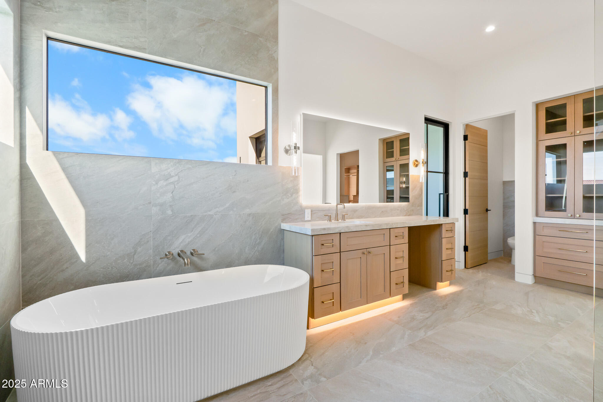 6260 South Key Biscayne Court Gilbert, AZ 85298 - Photo 27 of 68 a spacious bathroom with a double vanity sink a mirror a bathtub and a window