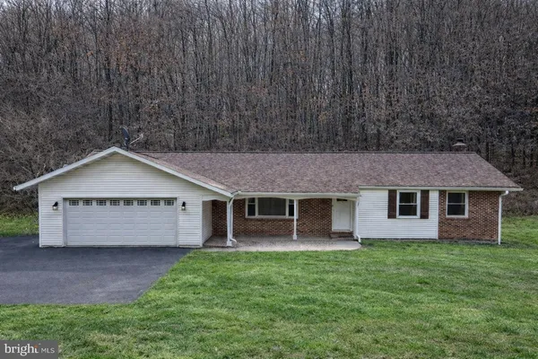 a front view of a house with a garden and yard