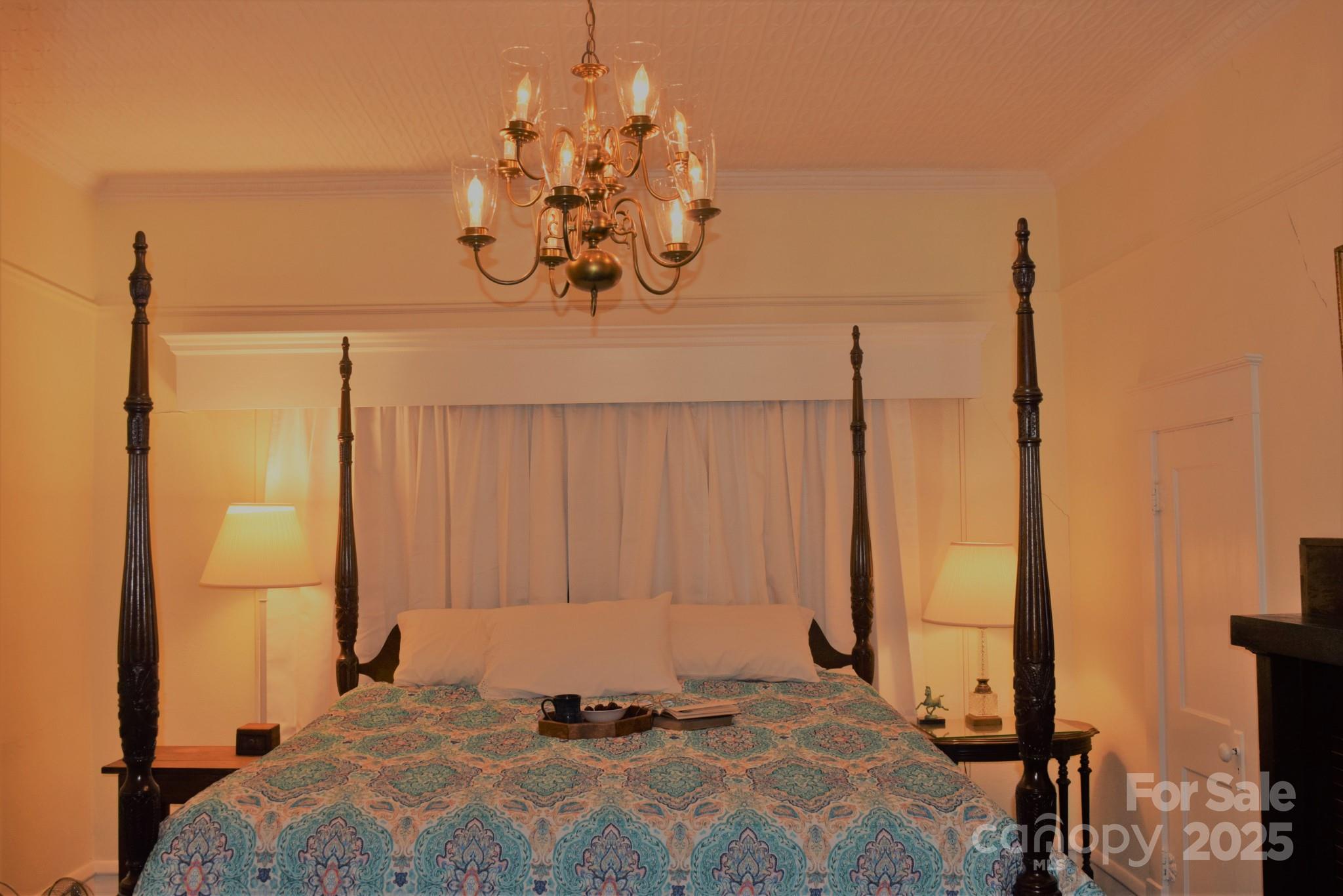 115 South Pearl Street Troy, NC 27371 - Photo 12 of 48 a bedroom with a bed and a chandelier