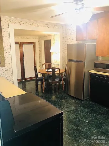 a view of a kitchen with a table and chairs in it