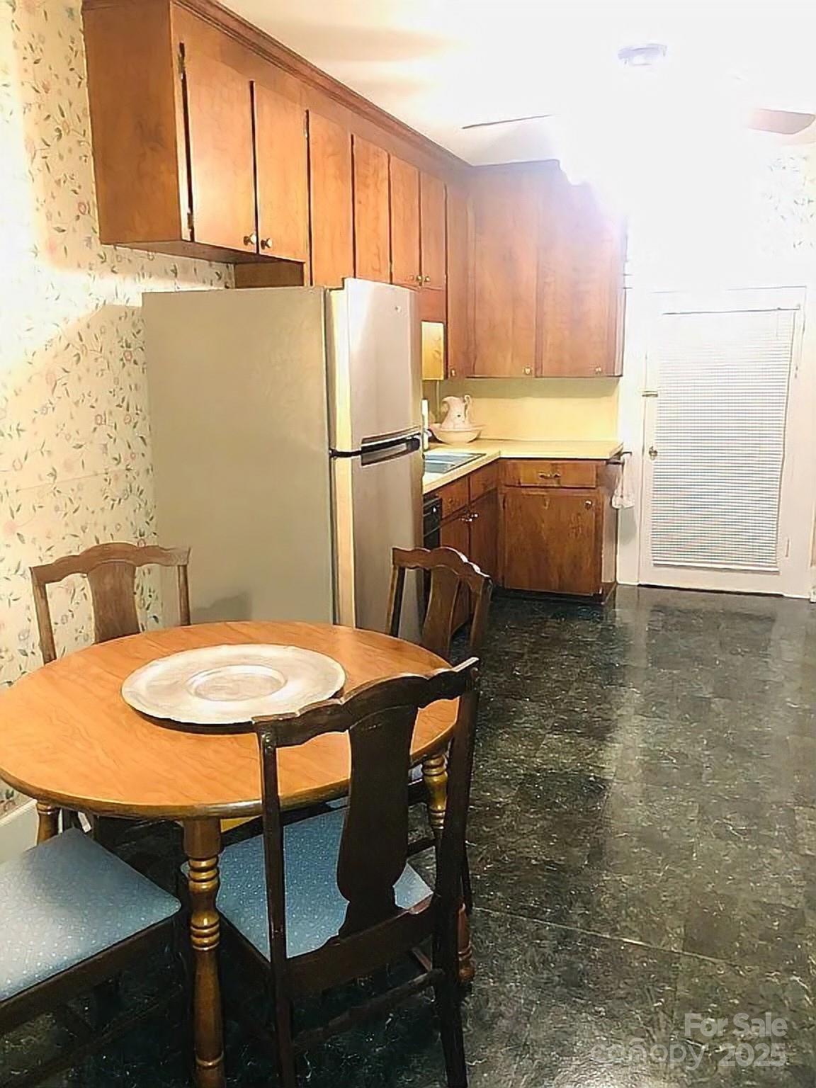 115 South Pearl Street Troy, NC 27371 - Photo 26 of 48 a kitchen with stainless steel appliances a table chairs and a refrigerator