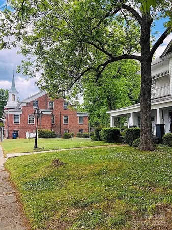 a view of a big yard with a house in the background