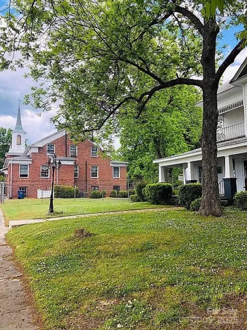 a view of a big yard with a house in the background