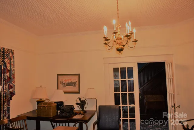 a view of a dining room with furniture and chandelier