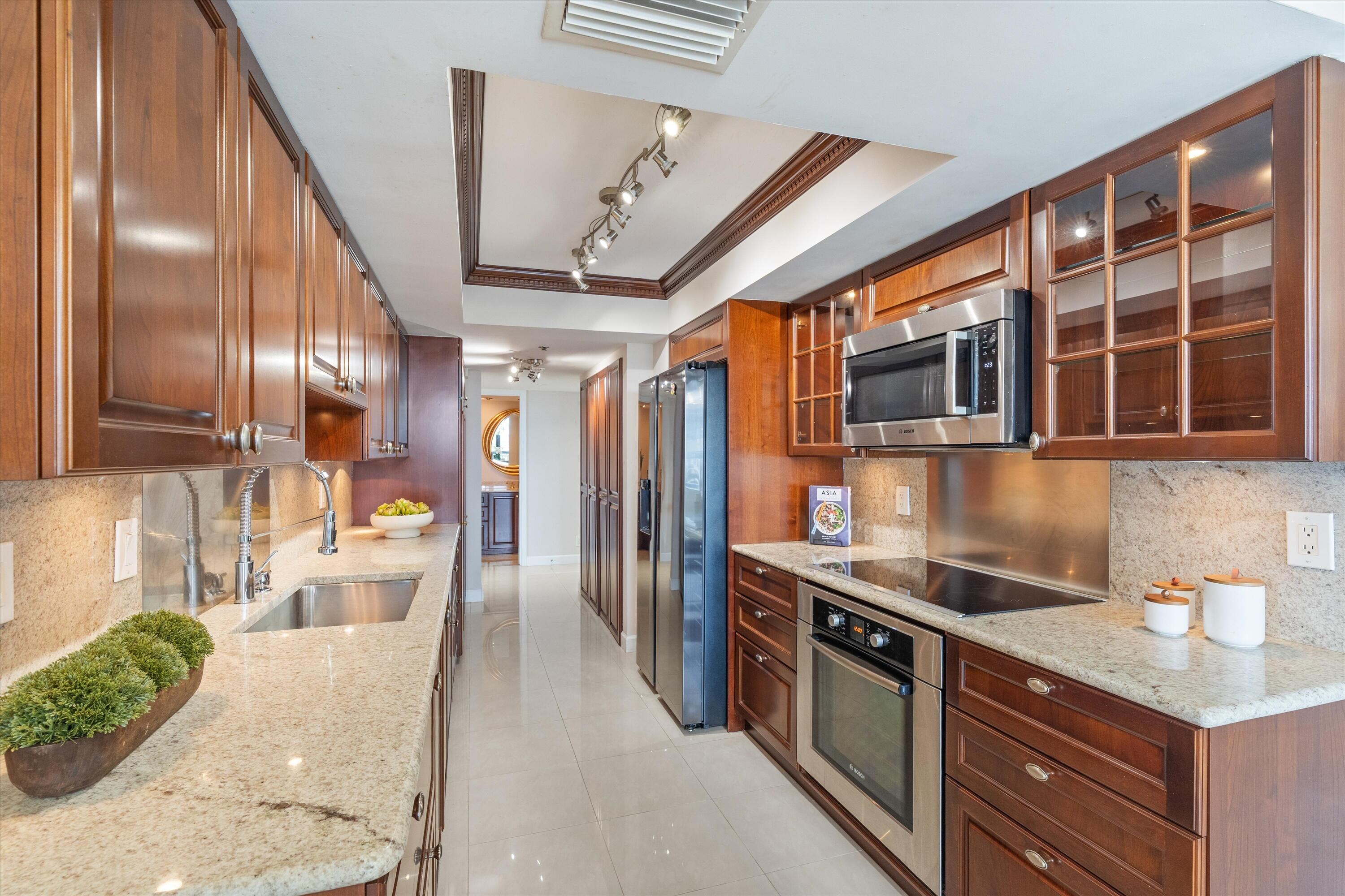 2003 North Ocean Boulevard, Unit 902 Boca Raton, FL 33431 - Photo 10 of 45 a kitchen with stainless steel appliances granite countertop a sink a stove and a refrigerator