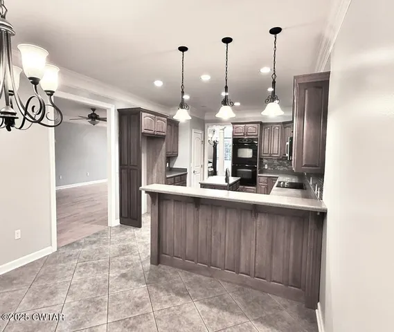 a open kitchen with a sink a center island a refrigerator and a counter top