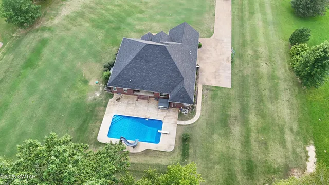 an aerial view of a house with swimming pool and garden