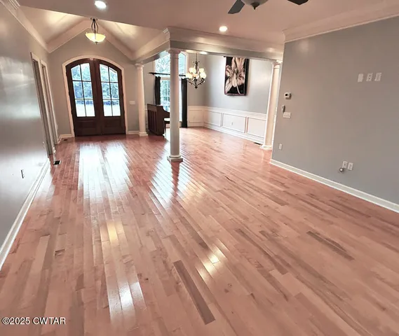a view of a room with wooden floor and entryway