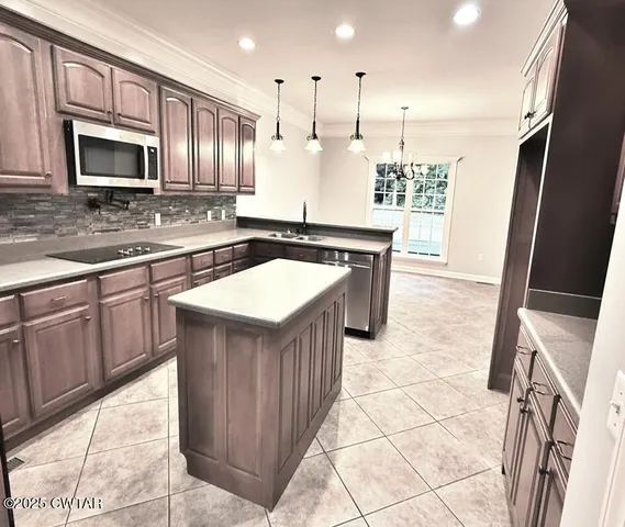 a kitchen with stainless steel appliances granite countertop a stove top oven microwave and cabinets