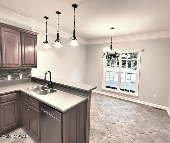 a kitchen with a sink chandelier and a wooden floor