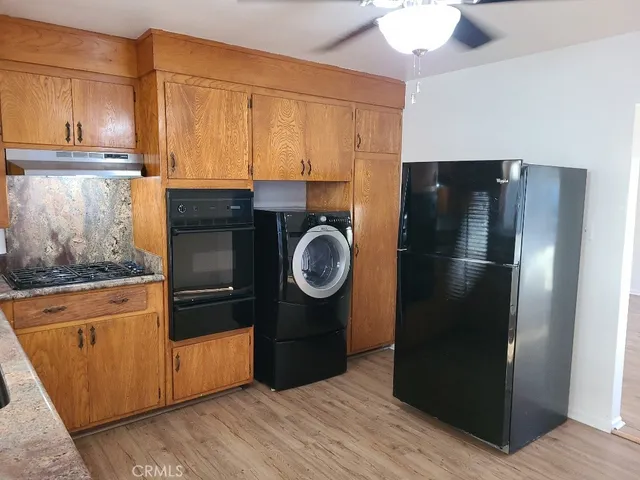 a kitchen with stainless steel appliances granite countertop a refrigerator and a stove top oven