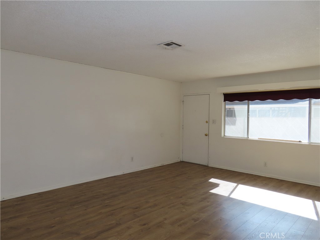 4041 MacArthur Road Riverside, CA 92503 - Photo 6 of 13 a view of an empty room with wooden floor and a window
