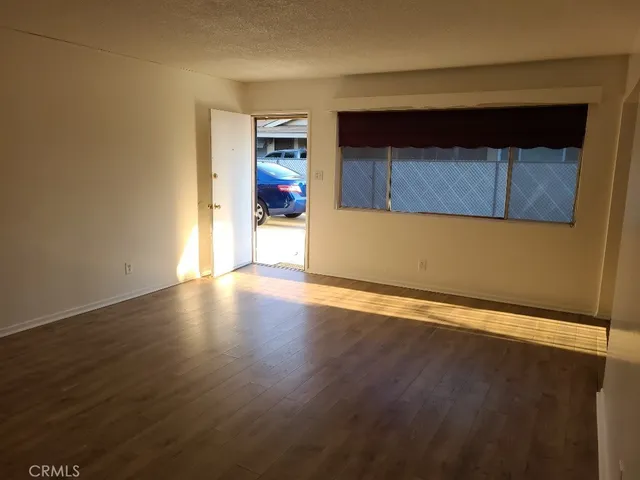 a view of a room with wooden floor and a window