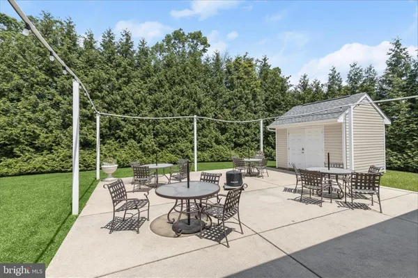 a view of a patio with a dining table and chairs with wooden fence