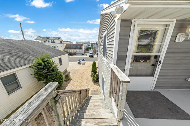 a view of a kitchen with white cabinets and wooden floor