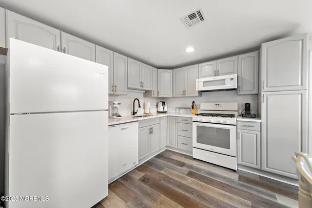 a view of a dining room with furniture a rug and wooden floor