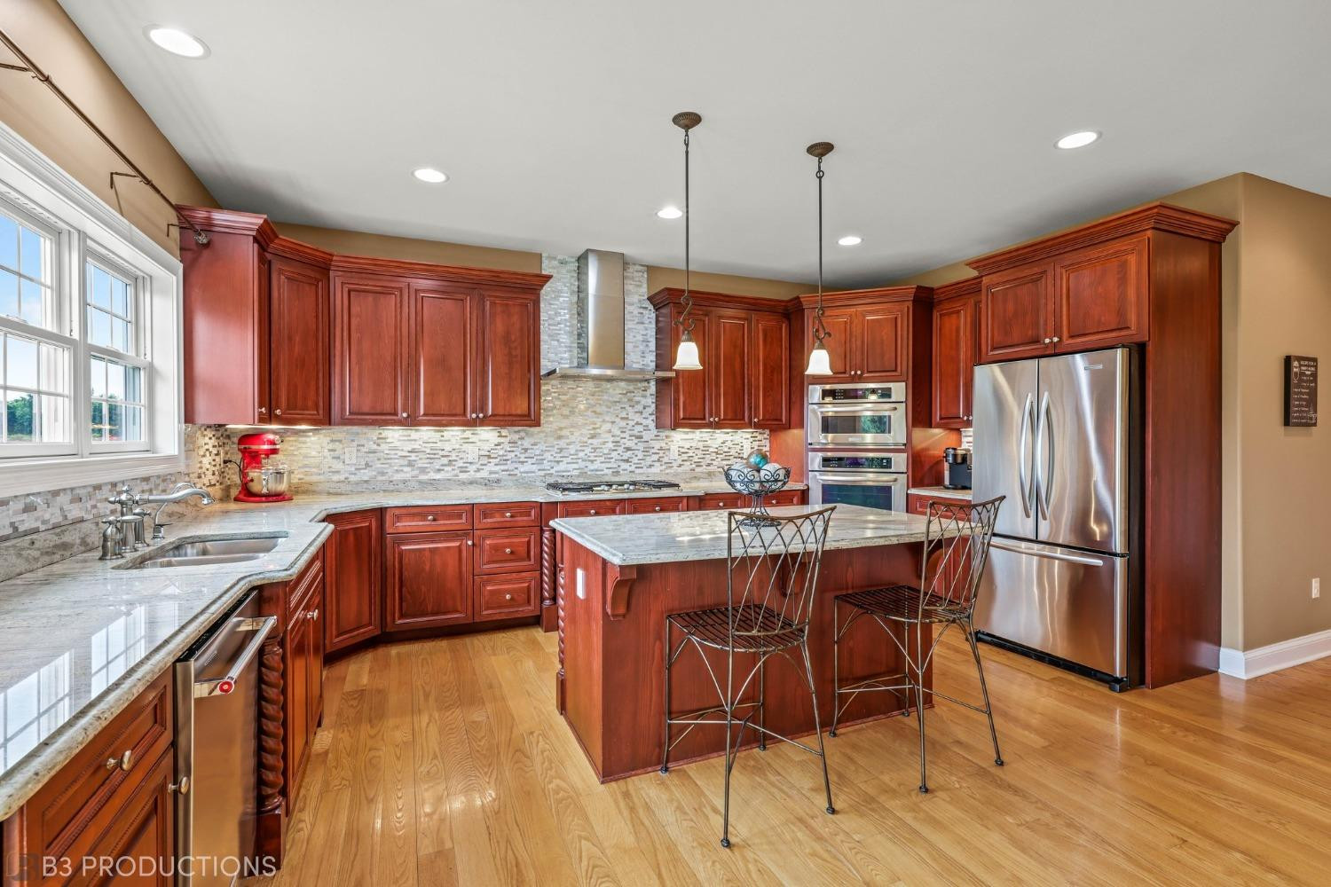 1825 Bramble Trace Chesterton, IN 46304 - Photo 9 of 30 a kitchen with stainless steel appliances granite countertop a refrigerator a sink dishwasher a stove and white countertops with wooden floor