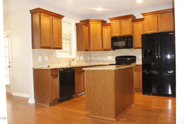 a kitchen with stainless steel appliances a refrigerator a stove a sink and a cabinets