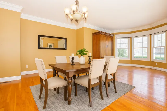a view of a livingroom with a fireplace a ceiling fan and wooden floor