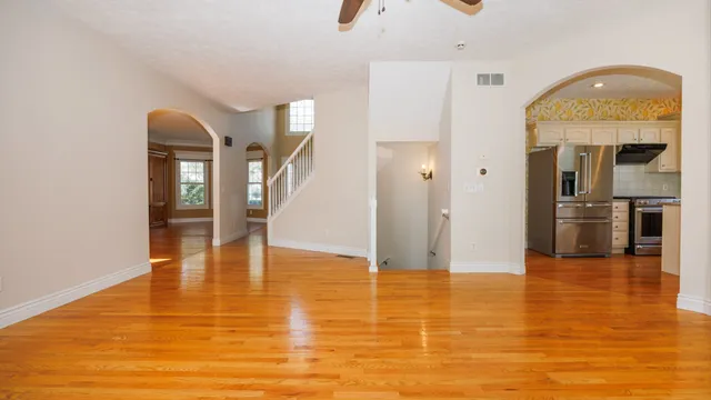 a view of a kitchen with kitchen island a sink wooden floor and a living room