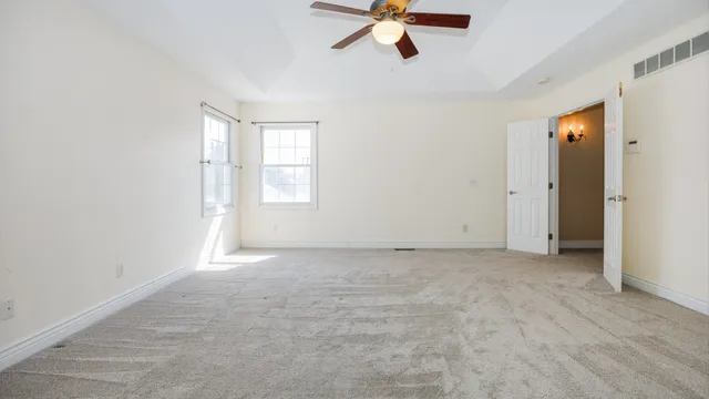 an empty room with closet and a chandelier fan