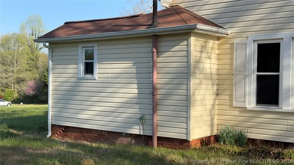 a view of house with backyard and outdoor seating