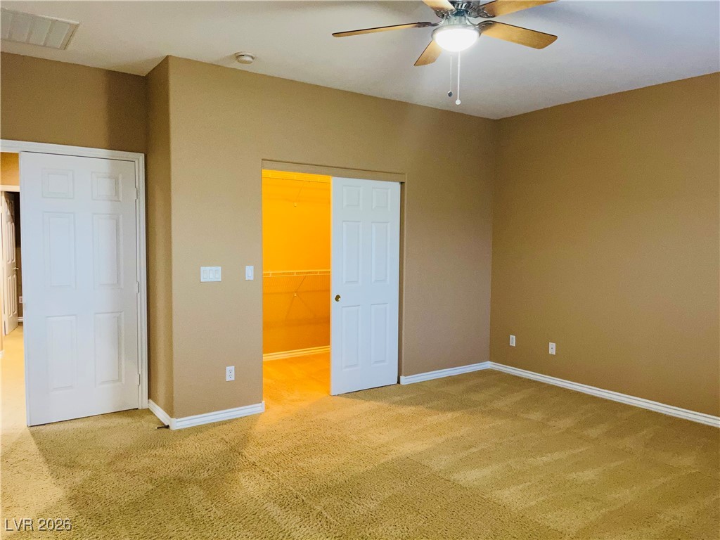259 Integrity Ridge Drive Henderson, NV 89052 - Photo 18 of 50 Primary bed w/ceiling fan & light, carpet & walk in closet.