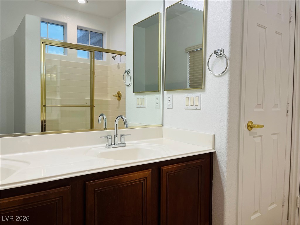 259 Integrity Ridge Drive Henderson, NV 89052 - Photo 23 of 50 Primary bath w/dual sinks, shower, cherry cabinets, corian counters w/new faucets & tile floors.