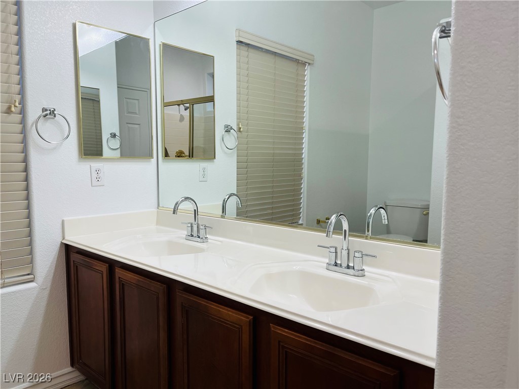 259 Integrity Ridge Drive Henderson, NV 89052 - Photo 24 of 50 Primary bath w/dual sinks, shower, cherry cabinets, corian counters w/new faucets & tile floors.