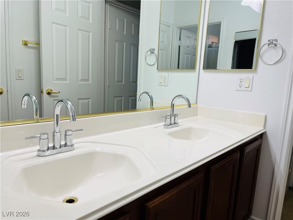 259 Integrity Ridge Drive Henderson, NV 89052 - Photo 39 of 50 Jack-n-jill bath w/dual sinks, cherry cabinets, corian counters w/new faucets w/tub & shower combo.