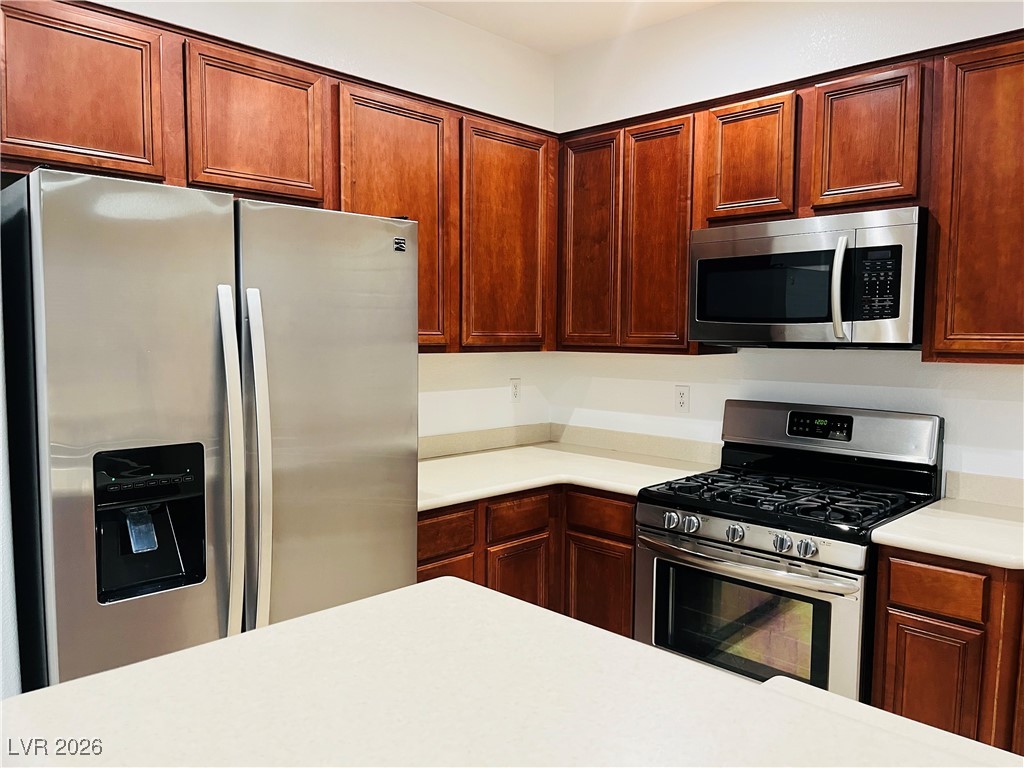 259 Integrity Ridge Drive Henderson, NV 89052 - Photo 7 of 50 Kitchen w/breakfast bar w/corian counters, cherry cabinets, SS appliances, tile floors, new sink & faucet, dining nook & pantry.