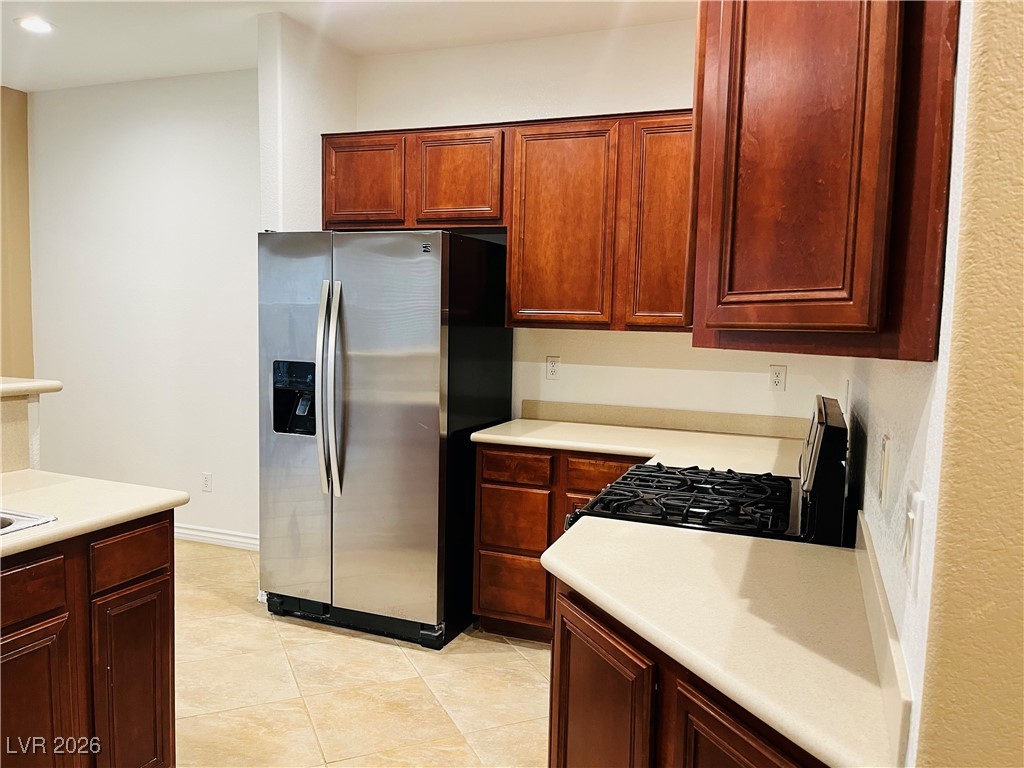 259 Integrity Ridge Drive Henderson, NV 89052 - Photo 9 of 50 Kitchen w/breakfast bar w/corian counters, cherry cabinets, SS appliances, tile floors, new sink & faucet, dining nook & pantry.