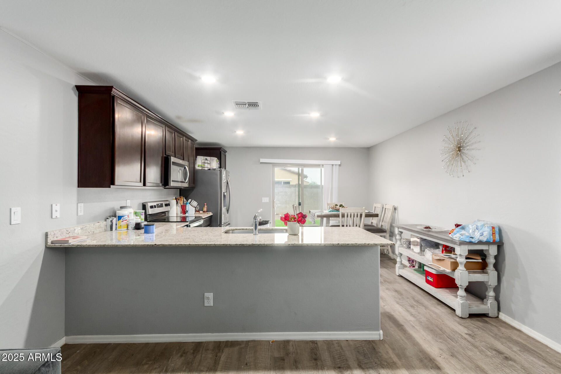 685 West 16th Street Florence, AZ 85132 - Photo 7 of 26 a kitchen with kitchen island a sink wooden floor and counter top space