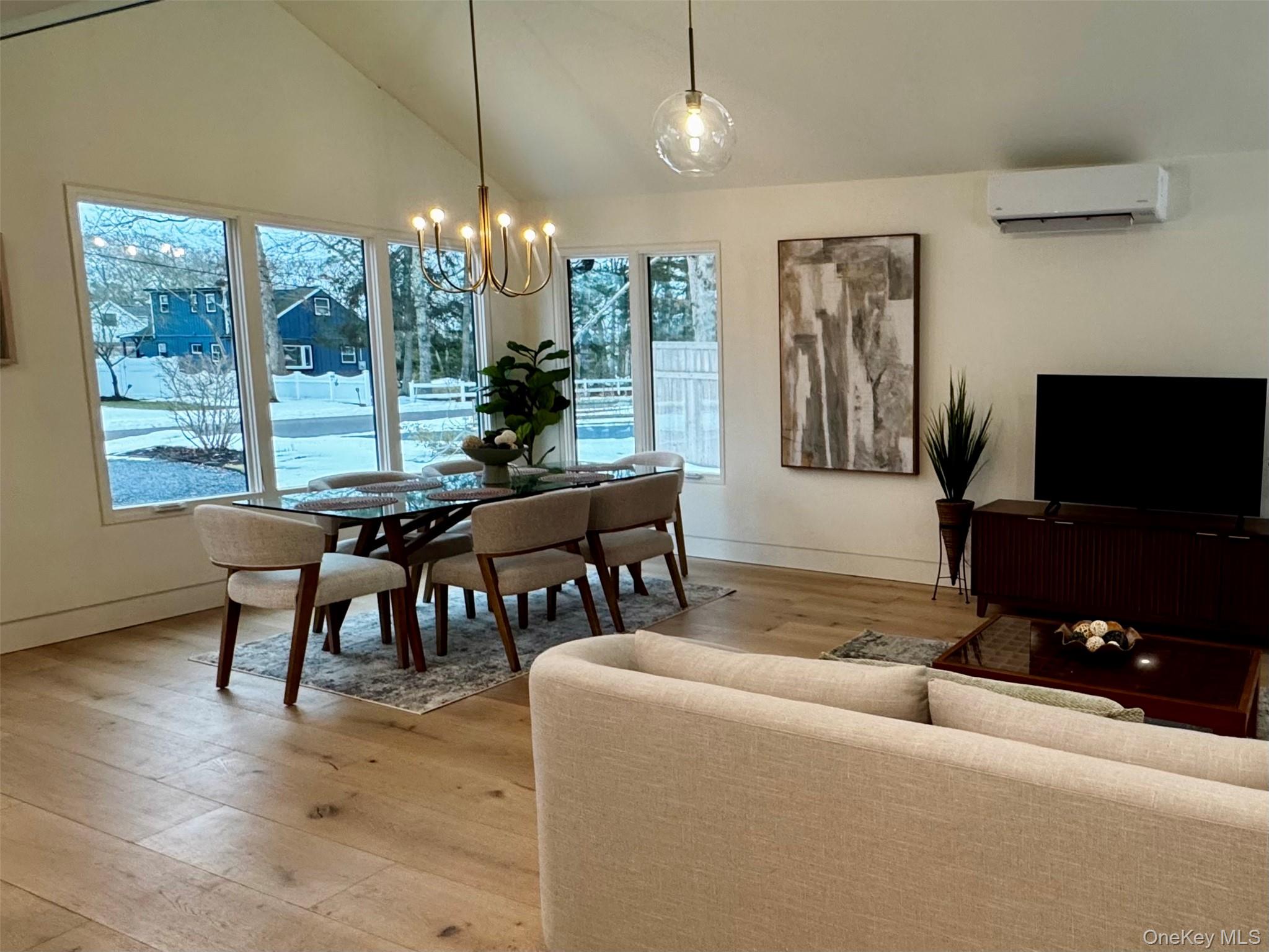 17 Heather Drive Remsenburg, NY 11960 - Photo 12 of 37 a living room with furniture a chandelier and a flat screen tv