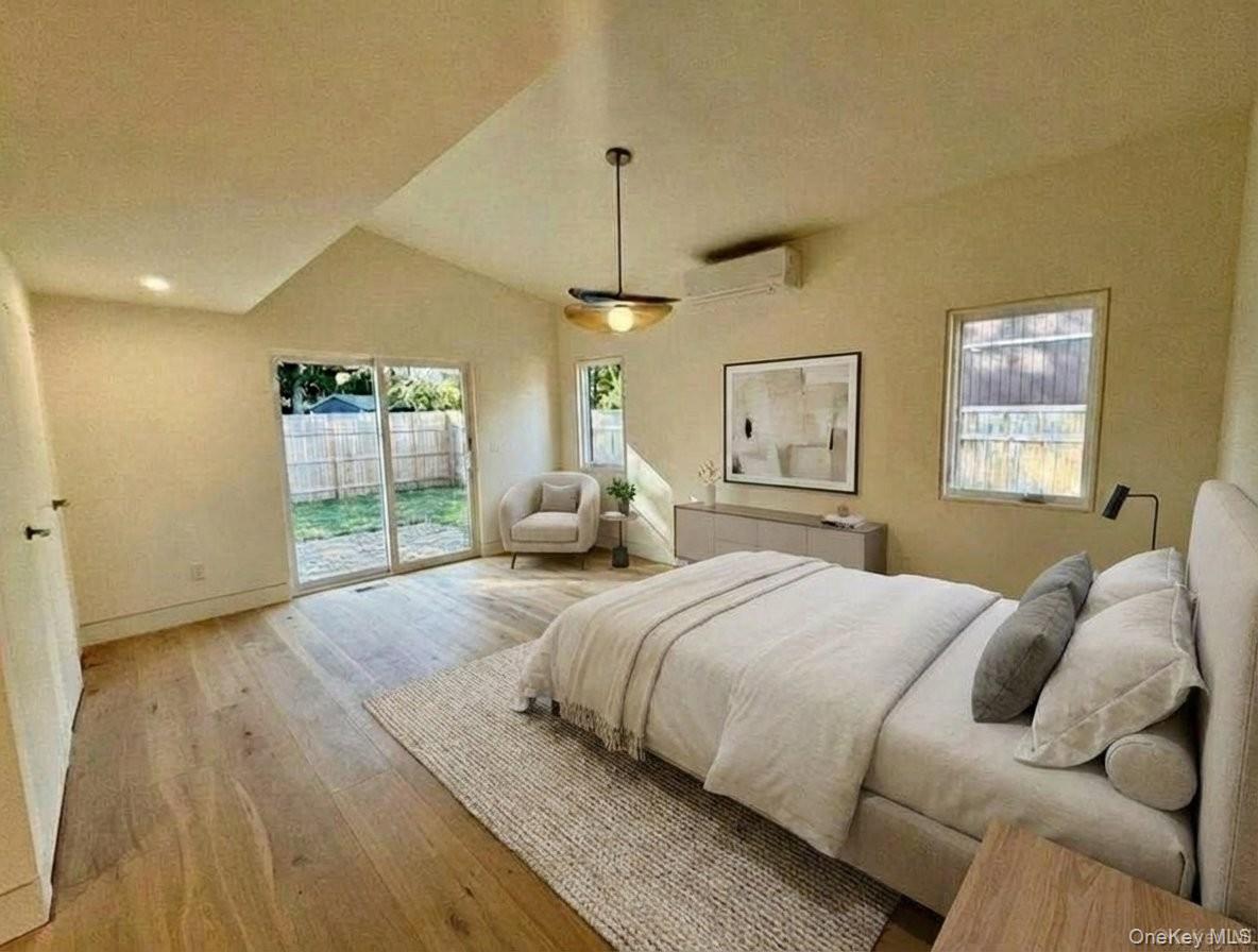 17 Heather Drive Remsenburg, NY 11960 - Photo 19 of 37 a bedroom with a large bed and a chandelier