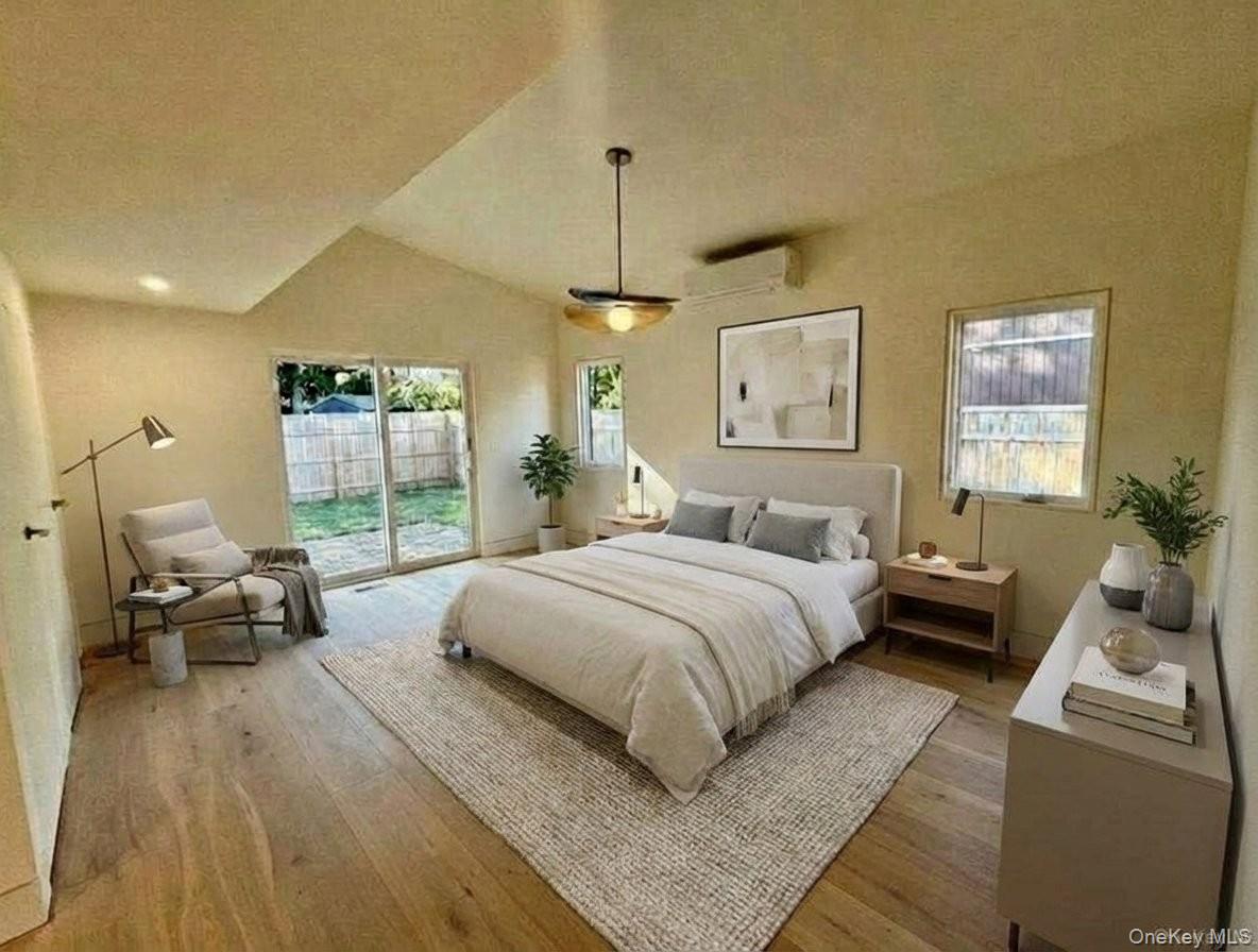 17 Heather Drive Remsenburg, NY 11960 - Photo 20 of 37 a spacious bedroom with a bed a couch and a window