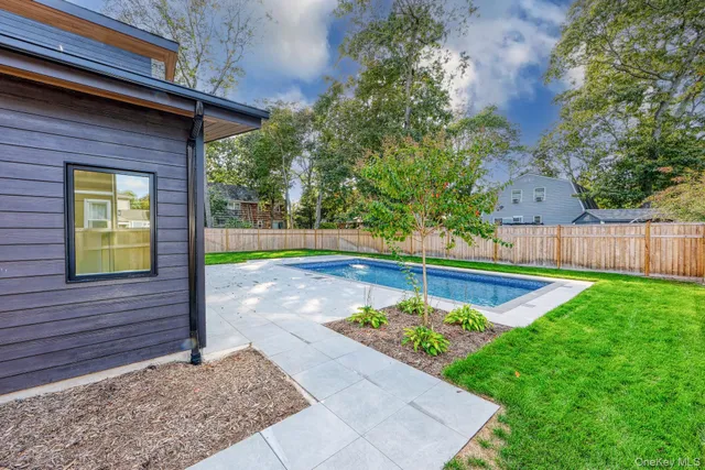 a view of a house with backyard and trees